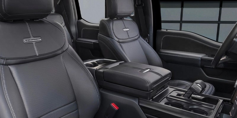 Black leather truck interior with "Platinum" seats, center console, cupholders, and gear shifter.