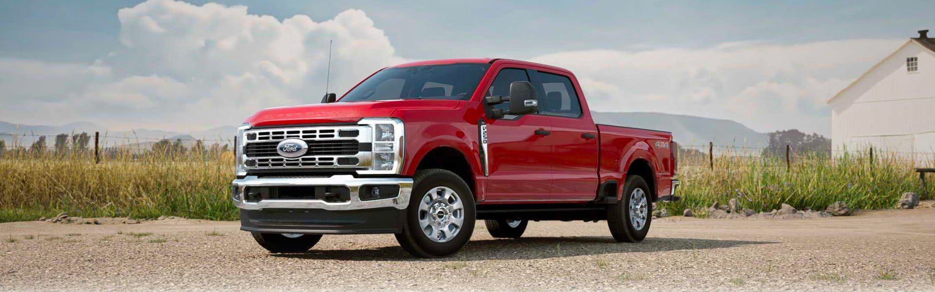 Red Ford F-250 Super Duty pickup truck parked on a gravel road