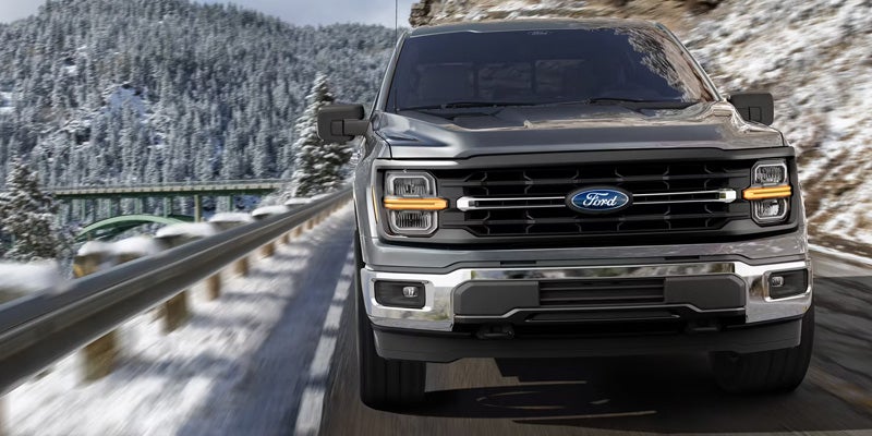Dark grey Ford F-150 driving on road