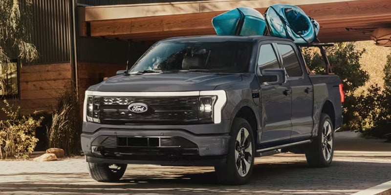 Grey Ford F-150 Lightning carrying kayaks