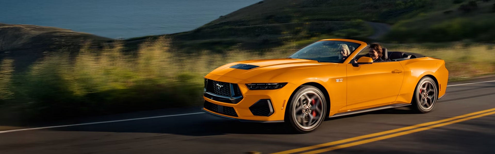 Ford Mustang convertible driving on road
